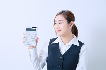 右手に持った計算機を見つめる若い事務員