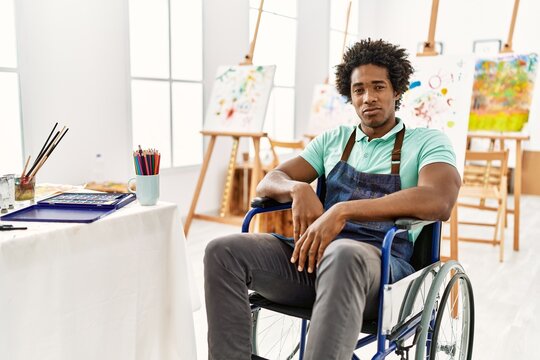 Young african american artist man sitting on wheelchair at art studio depressed and worry for distress, crying angry and afraid. sad expression.