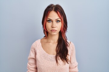 Obraz premium Young caucasian woman wearing pink sweater over isolated background relaxed with serious expression on face. simple and natural looking at the camera.