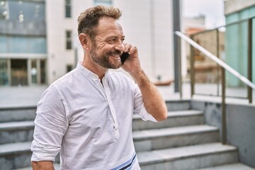 Middle age man talking to the phone at the city