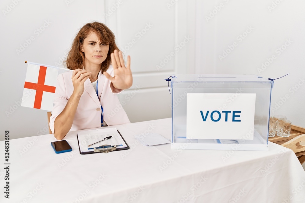 Canvas Prints Beautiful caucasian woman at political campaign election holding england flag with open hand doing stop sign with serious and confident expression, defense gesture