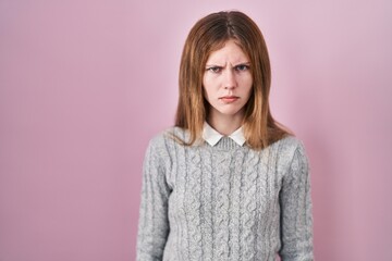 Beautiful woman standing over pink background skeptic and nervous, frowning upset because of...