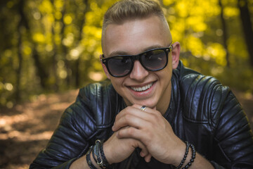 Smiling young handsome stylish student, blonde guy, lifestyle of teen- youth life. Portrait of young man