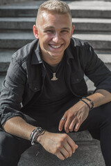 Smiling young handsome stylish student, blonde guy, lifestyle of teen- youth life. Portrait of young man