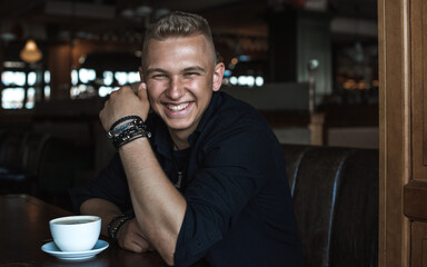 Smiling young handsome stylish student, blonde guy, lifestyle of teen- youth life. Portrait of young man