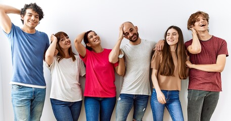 Group of young friends standing together over isolated background smiling confident touching hair with hand up gesture, posing attractive and fashionable