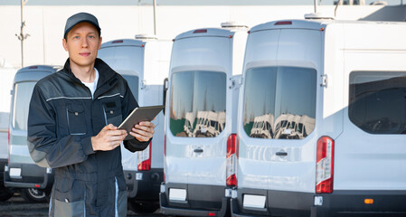 Manager with a digital tablet on the background of buses. Fleet management