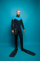 Man diver standing on blue studio background