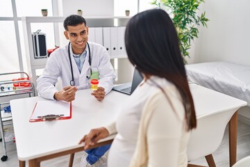 Young latin couple doctor and patient having medical session holding urine test tube at clinic