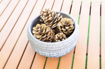picture of real pinecones in vase on wooden table
