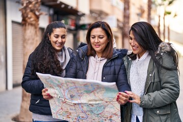 Three woman mother and daughters holding map at street