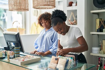 African american women shop assistants smiling confident working at clothing store