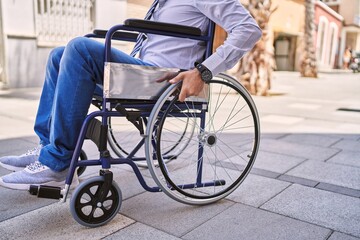 Obraz premium Middle age hispanic man wearing business clothes sitting on wheelchair at street
