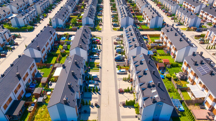 Obraz premium An aerial view of the houses and streets. A residential area in the suburbs. Houses and private yards. View of townhouses from the drone. Photo for building design.