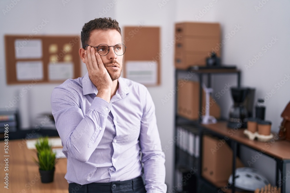 Poster Young hispanic man at the office tired hands covering face, depression and sadness, upset and irritated for problem