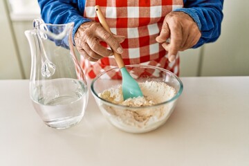Senior man cooking dough at kitchen