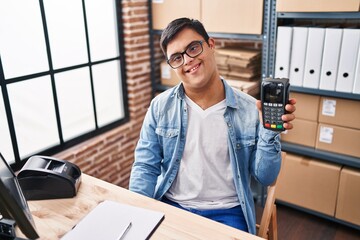Down syndrome man ecommerce business worker holding data phone at office