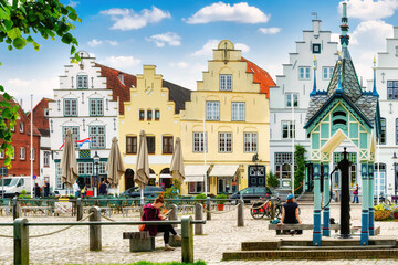 Historic houses and market fountain on the market sqaure of the idyllic old town of Friedrichstadt, Germany