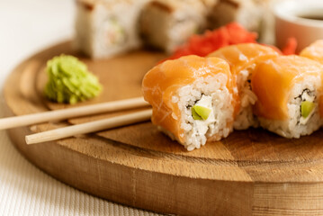 Set of delicious salmon philadelphia sushi roll served with wasabi cream and chopstick on wooden...