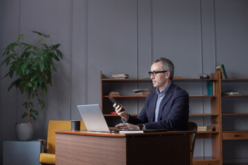 Portrait of middle-aged man using smartphone. Businessman working in office