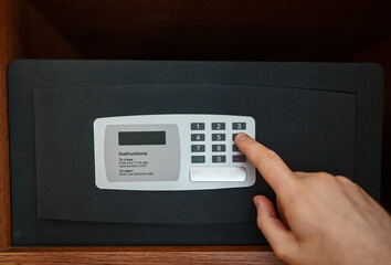 Man's hand opening small safe.