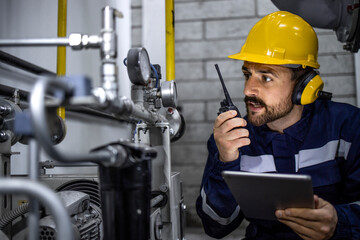 Factory worker checking gas pipeline pressure and consumption.