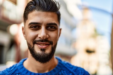 Young arab man smiling confident at street