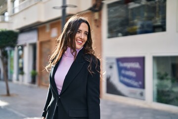 Young hispanic woman smiling confident standing at street