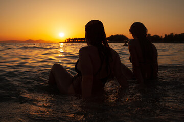 Close up happy smiling young couple two friends rest together at sunrise over sea beach ocean outdoor seaside in summer day sunset evening.