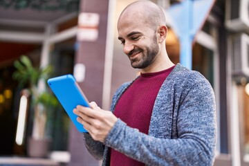 Fototapeta premium Young man smiling confident using touchpad at street