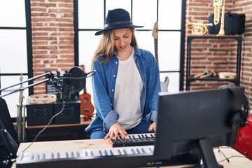 Young blonde woman musician having dj session at music studio