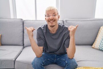 Young caucasian man wearing virtual reality glasses looking confident with smile on face, pointing oneself with fingers proud and happy.