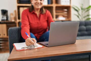 Middle age hispanic woman psychologist using laptop at psychology center