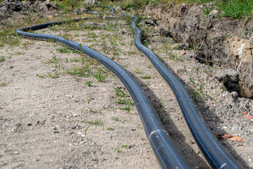Plastic water pipe lying along the ditch with high groundwater, water connection in the housing...