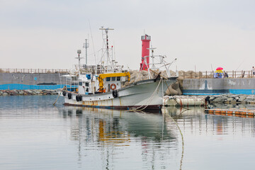 Fototapeta premium fishing boats in port, red light house, breakwater