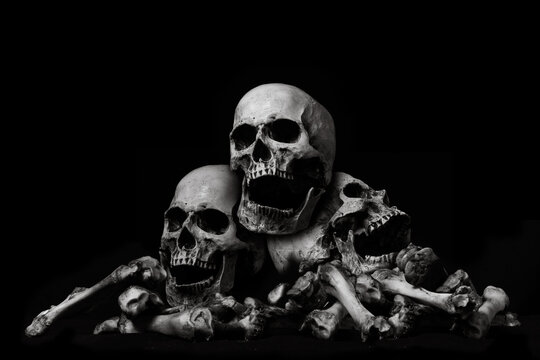 Awesome pile of skull human and bone on wooden, black cloth background, concept of scary crime scene of horror or thriller movies,Halloween theme, Still Life style, selective focus,