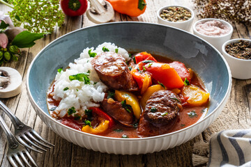 Delicious stew - vegetable with sausages on wooden table
