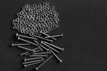 Metal nuts and bolts close up on black background