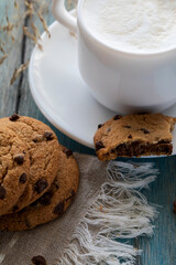 Chocolate chip cookies and a cup of latte on a blue wooden table