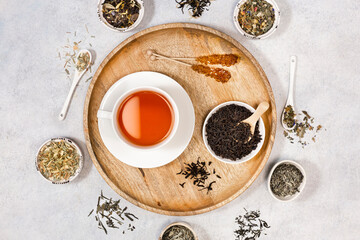 A cup of tea and coockies and sugar on a wooden tray. Various types of tea. View from above.