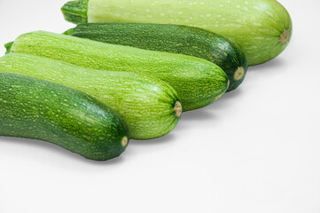 fresh zucchini on a white background. delicious green vegetables on the table. appetizing zucchini on a light texture. healthy food concept