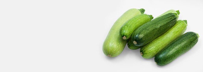 fresh zucchini on a white background. delicious green vegetables on the table. appetizing zucchini on a light texture. healthy food concept