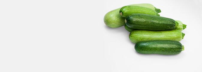 fresh zucchini on a white background. delicious green vegetables on the table. appetizing zucchini on a light texture. healthy food concept