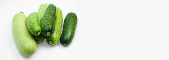fresh zucchini on a white background. delicious green vegetables on the table. appetizing zucchini on a light texture. healthy food concept