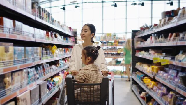 Mother looks for products with excited daughter in store