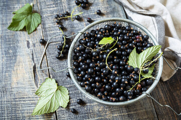 Raw organic berries. The concept of vitamin c food. Fresh black currants on a wooden table in rustic style.
