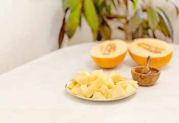 Slices of ripe melon with honey on a plate on a white background. Healthy eating