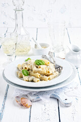 Traditional Italian pasta rigatoni al gorgonzola with vongole and cheese served as close-up on a classic design plate