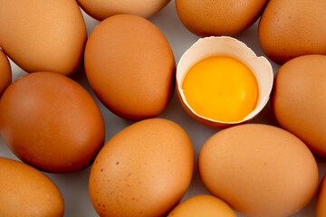 Broken egg with whole brown eggs. Egg yolk. Egg background
