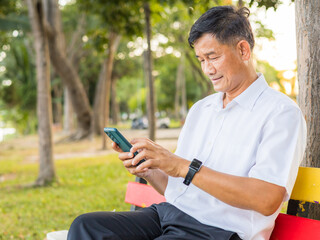 Senior male using smartphone at park. senior lifestyle concept.